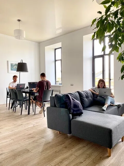 tres personas compartiendo piso trabajndo en el salón